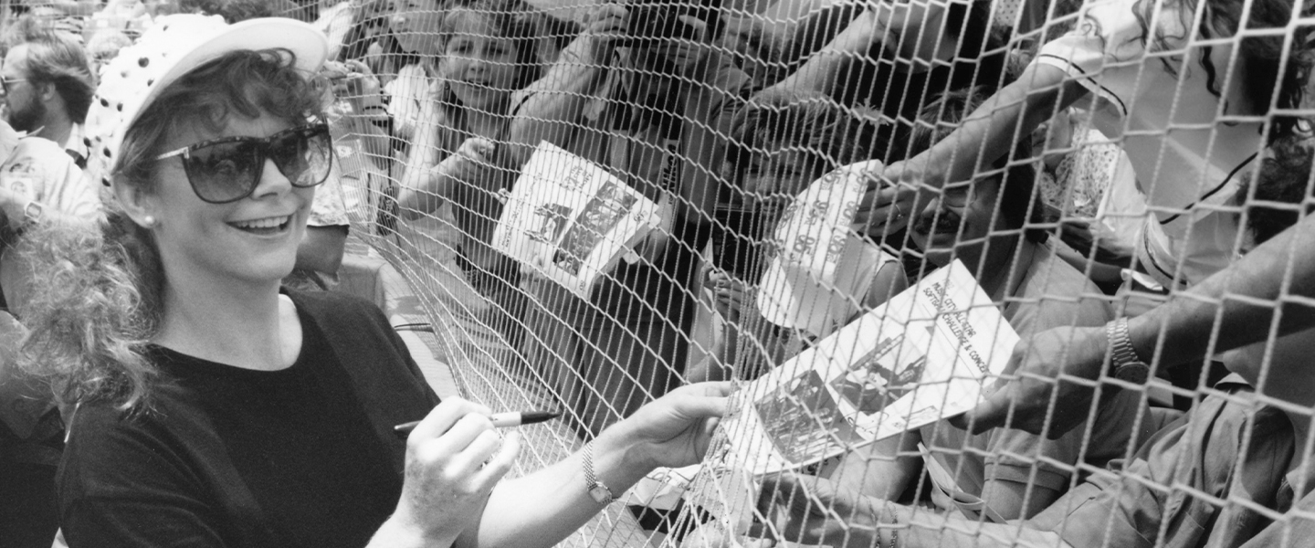 Reba signing autographs through fence 